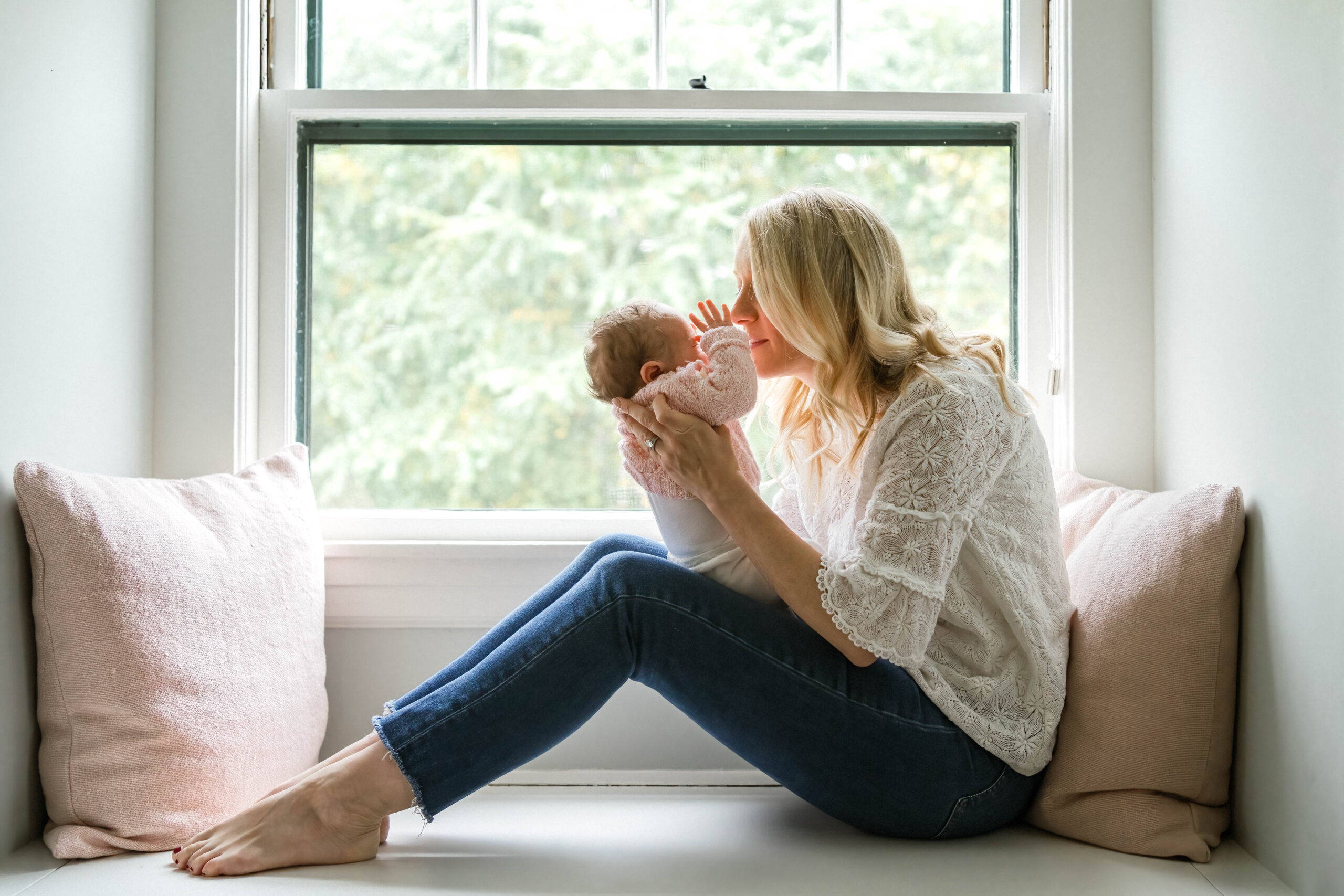 Image of mother and newborn daughter sitting in window seat