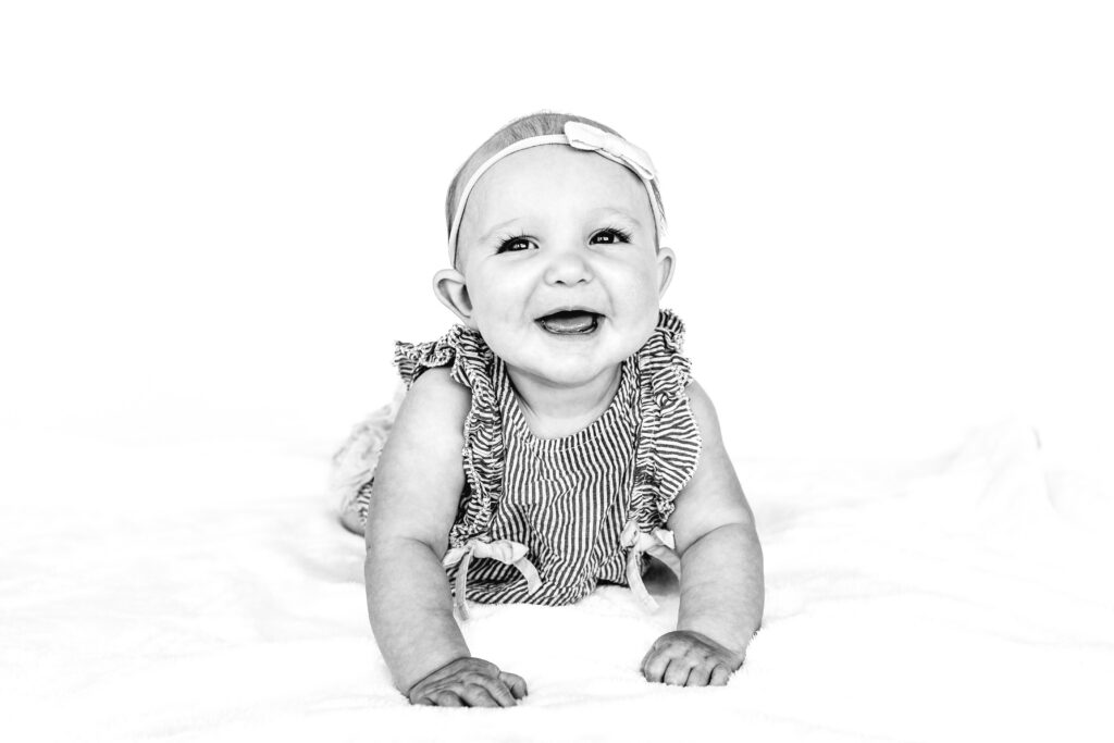 Black and white personality portrait of young 6 month old baby girl.